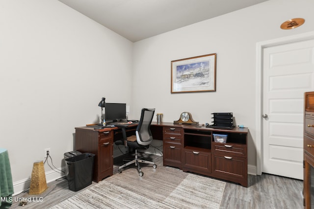 office space with light wood-style flooring and baseboards
