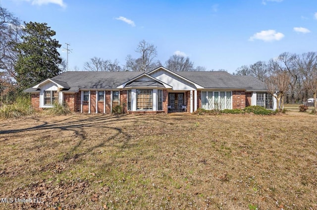 single story home featuring a front lawn and brick siding