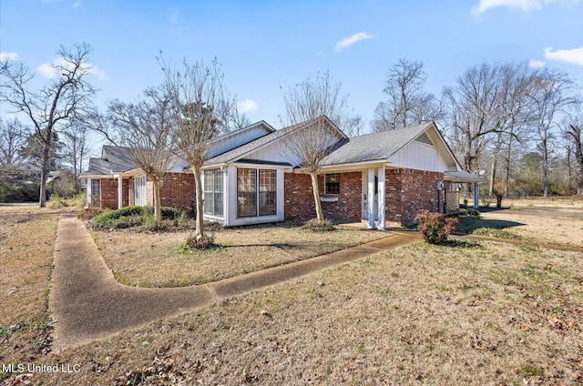 ranch-style home featuring brick siding and a front lawn