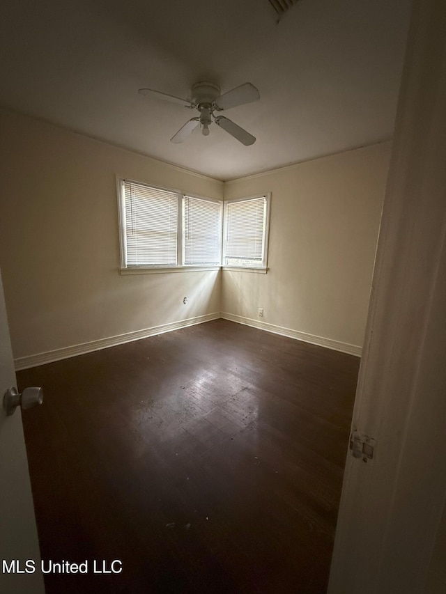 spare room with ceiling fan and dark hardwood / wood-style flooring