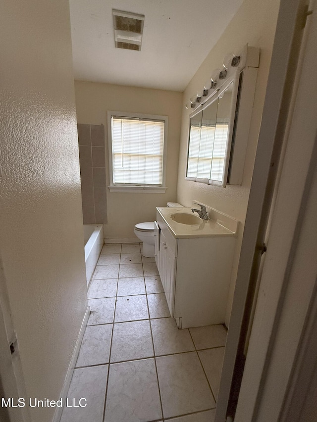 bathroom featuring tile patterned flooring, vanity, toilet, and a washtub