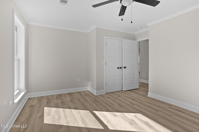 unfurnished bedroom with light wood-style flooring, a closet, ornamental molding, and baseboards