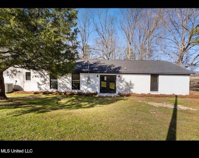 view of front facade featuring central AC unit, a front lawn, and french doors