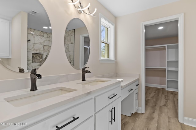 full bathroom with wood finished floors, visible vents, a sink, and a walk in shower