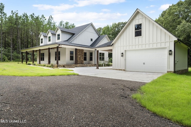 563 Valentine Rd, Holly Springs, MS 38635 - modern farmhouse style home with concrete driveway, board and batten siding, a front yard, a garage, and covered porch