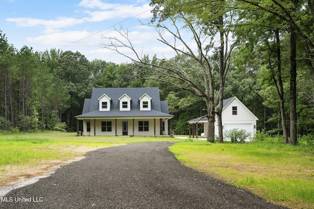 563 Valentine Rd, Holly Springs, MS 38635 - view of front of property featuring a porch, an outbuilding, driveway, a detached garage, and a forest view