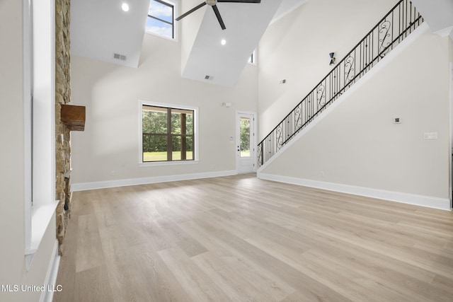 563 Valentine Rd, Holly Springs, MS 38635 - unfurnished living room with ceiling fan, a towering ceiling, stairs, and light wood finished floors