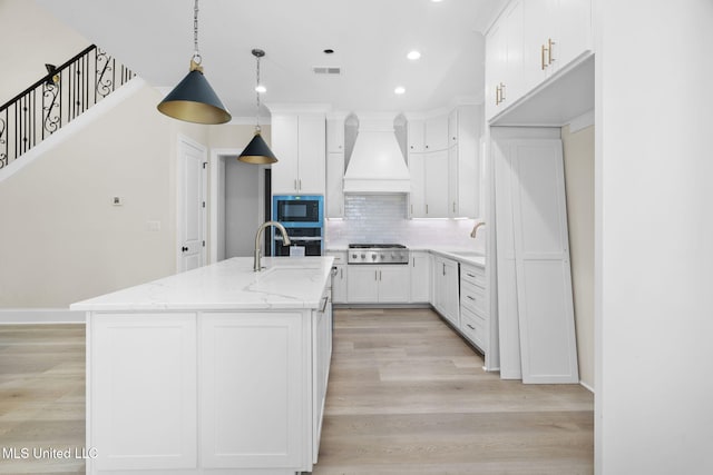 563 Valentine Rd, Holly Springs, MS 38635 - kitchen with custom exhaust hood, black appliances, recessed lighting, backsplash, and a kitchen island with sink