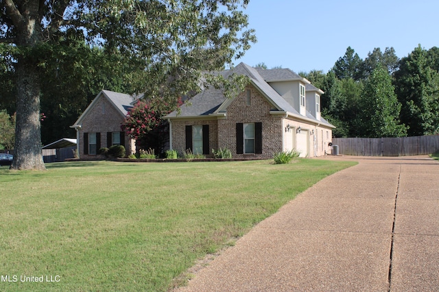 traditional-style home with an attached garage, brick siding, fence, concrete driveway, and a front lawn