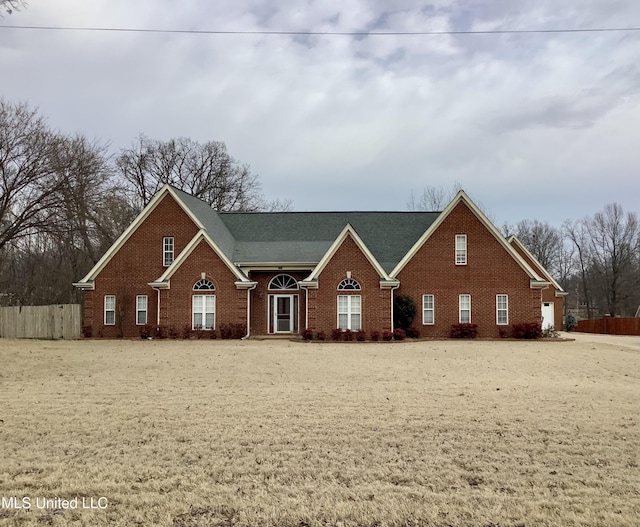 view of front of home with brick siding and fence