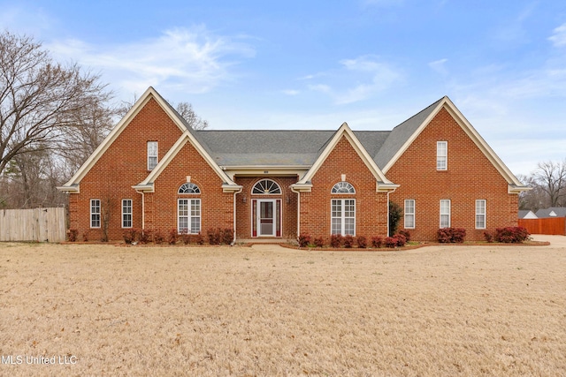 traditional-style home with brick siding and fence