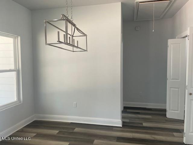 unfurnished dining area with dark wood-type flooring