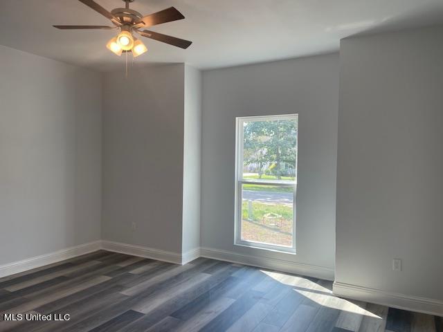 unfurnished room featuring ceiling fan and dark hardwood / wood-style flooring