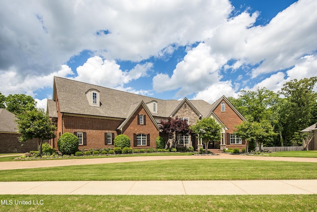 view of front of property featuring brick siding and a front yard