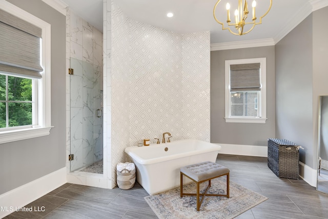 full bath with a chandelier, a marble finish shower, baseboards, a freestanding tub, and ornamental molding