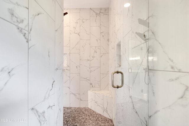 bathroom featuring a marble finish shower
