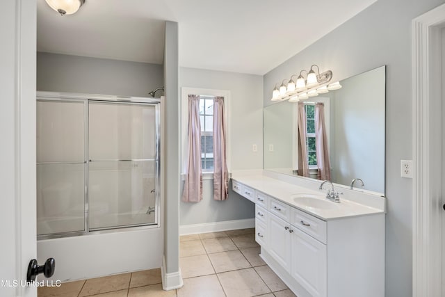 bathroom featuring tile patterned floors, vanity, shower / bath combination with glass door, and baseboards