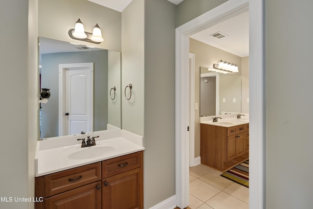bathroom with tile patterned flooring, two vanities, and baseboards