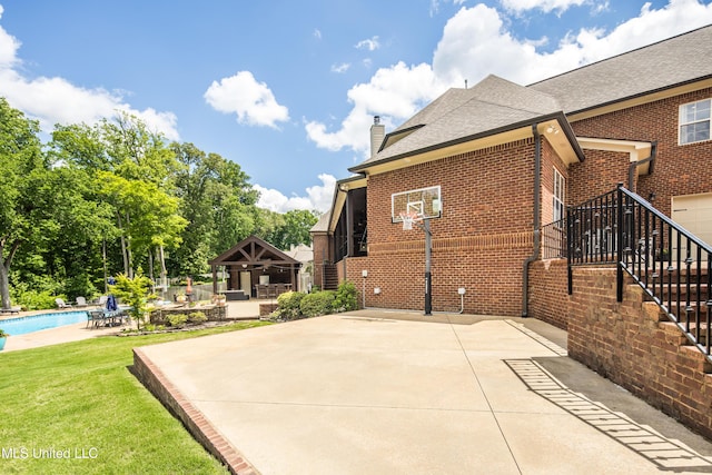view of basketball court with an outdoor pool and basketball hoop