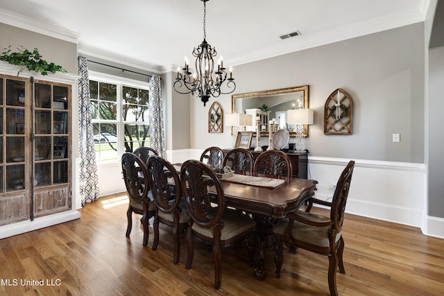 dining room featuring a chandelier, crown molding, and wood finished floors