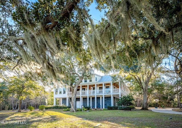 view of front of house featuring a front yard and a balcony