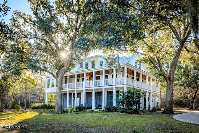 view of front of house with a balcony and a front yard