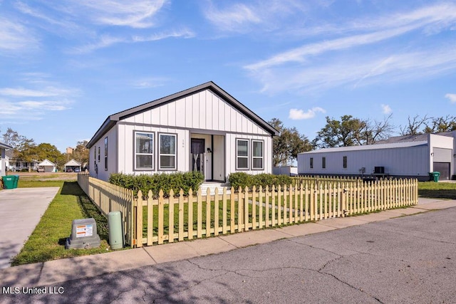 modern inspired farmhouse featuring a front lawn and a fenced front yard