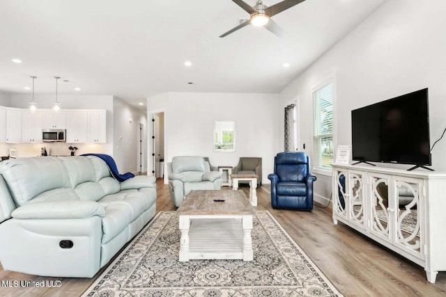 living room with ceiling fan and light wood-type flooring