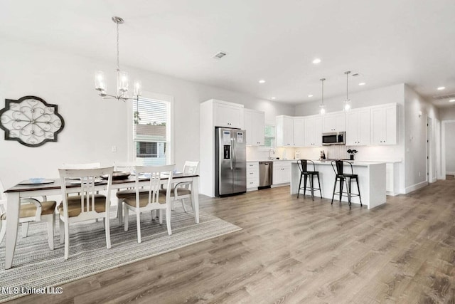 dining space featuring a chandelier and light hardwood / wood-style floors