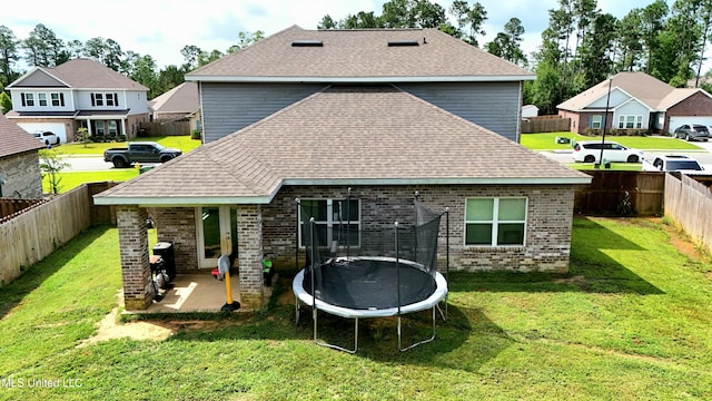 5065 Fairbury Way, Diberville, MS 39540 - back of property with a trampoline, brick siding, a patio area, a shingled roof, and a residential view