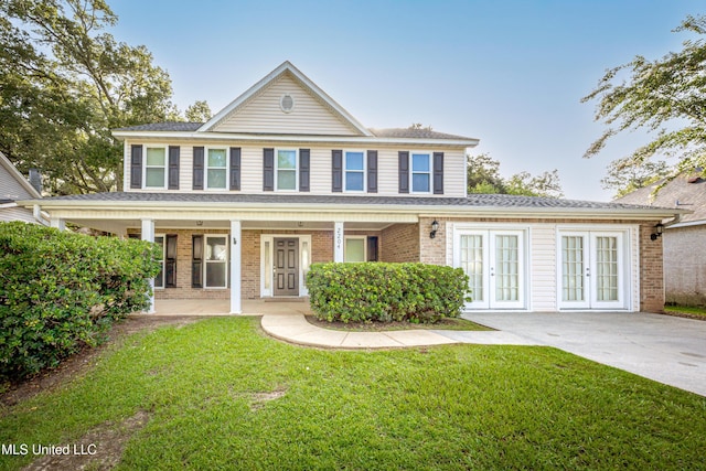 2204 Rue Beaux Chenes, Ocean Springs, MS 39564 - view of front facade featuring french doors, a front lawn, and brick siding