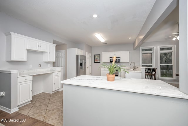 2204 Rue Beaux Chenes, Ocean Springs, MS 39564 - kitchen featuring stainless steel appliances, white cabinetry, ceiling fan, recessed lighting, and a center island with sink