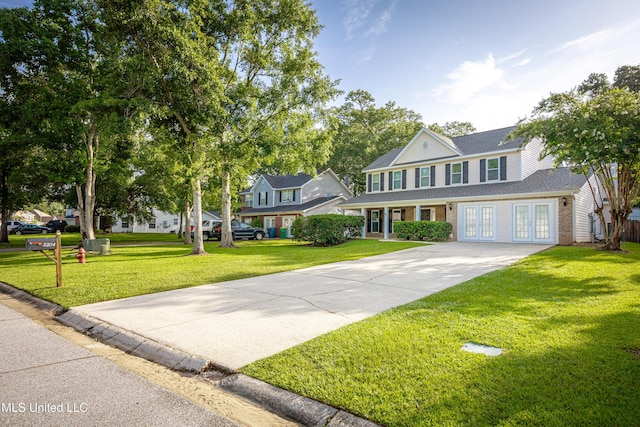 2204 Rue Beaux Chenes, Ocean Springs, MS 39564 - view of front of house featuring french doors, concrete driveway, a front yard, and brick siding