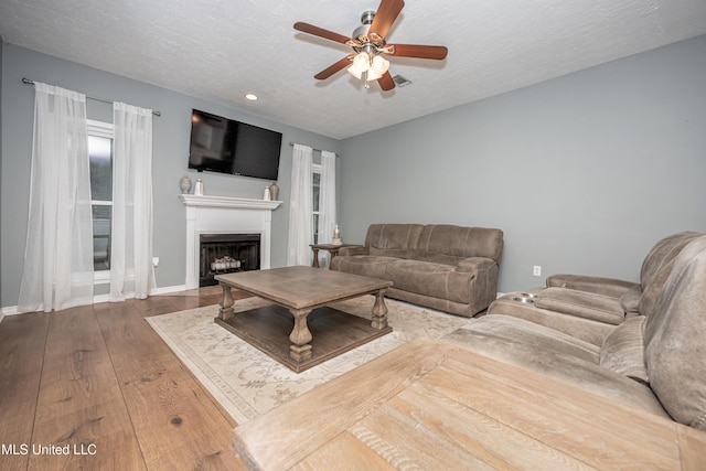 2204 Rue Beaux Chenes, Ocean Springs, MS 39564 - living room with ceiling fan, a fireplace, wood finished floors, a textured ceiling, and recessed lighting