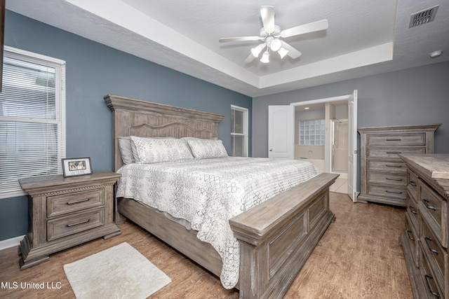 2204 Rue Beaux Chenes, Ocean Springs, MS 39564 - bedroom with wood finished floors, a tray ceiling, and ceiling fan