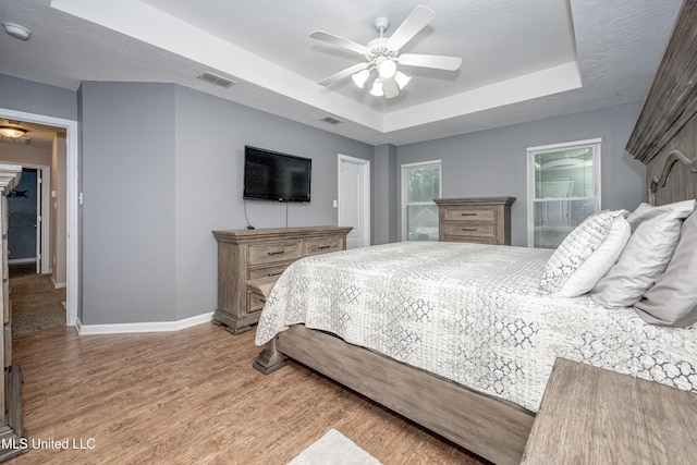 2204 Rue Beaux Chenes, Ocean Springs, MS 39564 - bedroom with a tray ceiling, light wood finished floors, and ceiling fan