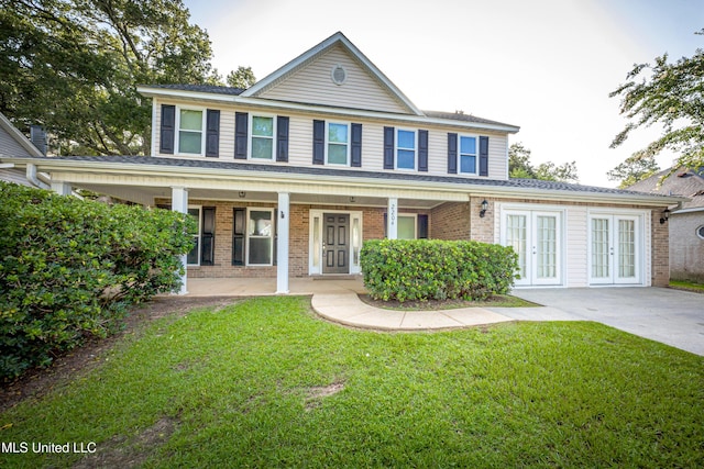 2204 Rue Beaux Chenes, Ocean Springs, MS 39564 - view of front facade with french doors, a front lawn, and brick siding