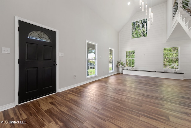 foyer with wood-type flooring and high vaulted ceiling