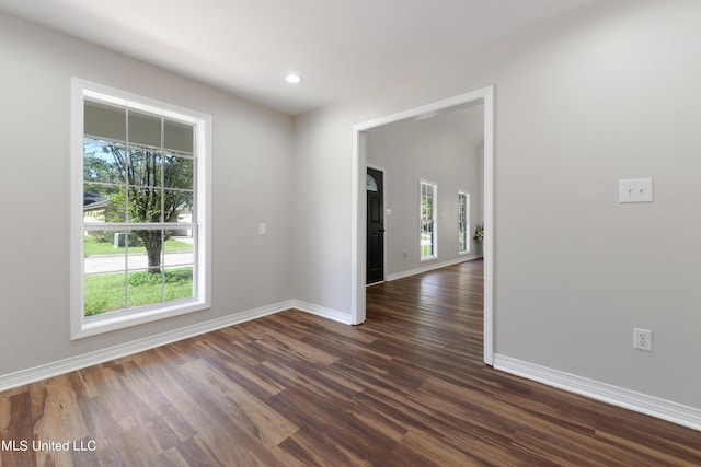 unfurnished room with dark hardwood / wood-style flooring