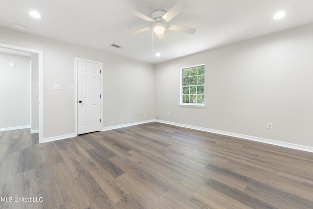 empty room with dark hardwood / wood-style floors and ceiling fan