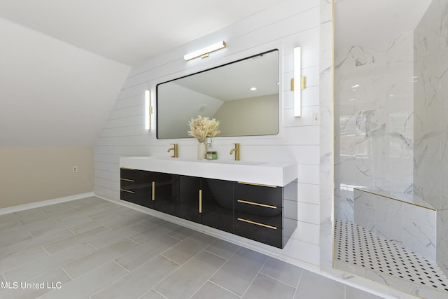 bathroom with vanity, tiled shower, and vaulted ceiling