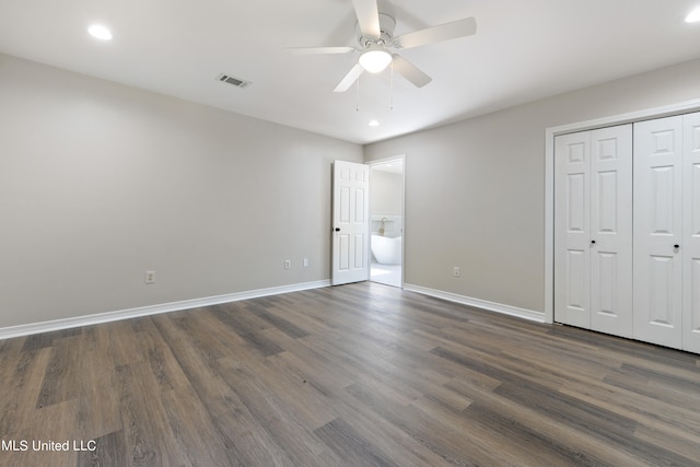 unfurnished bedroom with a closet, dark wood-type flooring, and ceiling fan