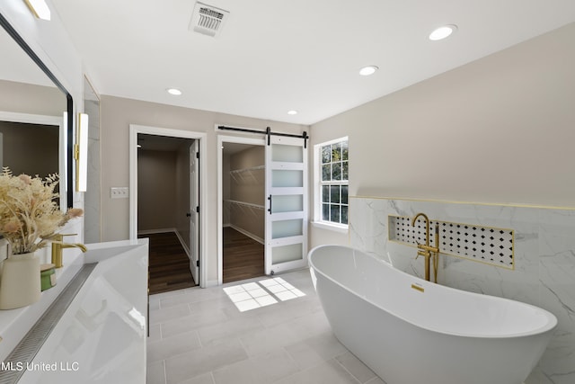 bathroom with wood-type flooring, a washtub, and tile walls