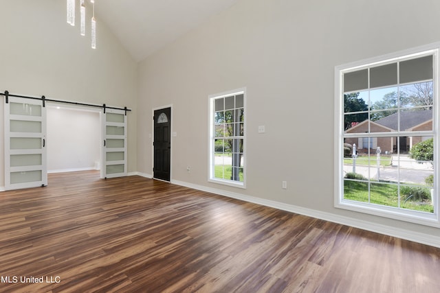 unfurnished bedroom featuring multiple windows, high vaulted ceiling, and dark wood-type flooring