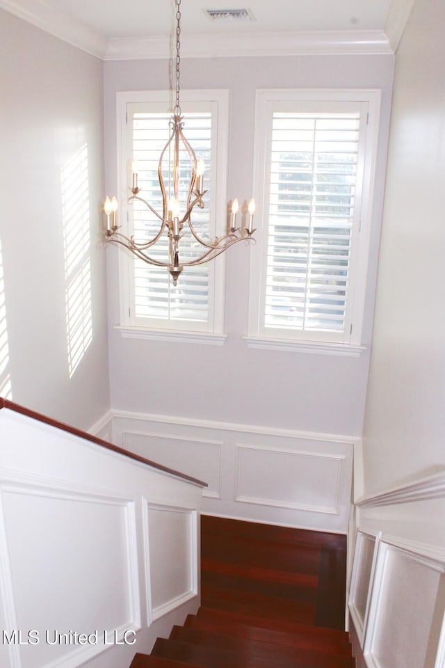 interior space with ornamental molding and an inviting chandelier