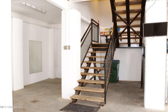 stairs featuring concrete flooring