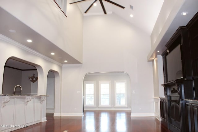 living room with dark wood-type flooring, an inviting chandelier, crown molding, and sink