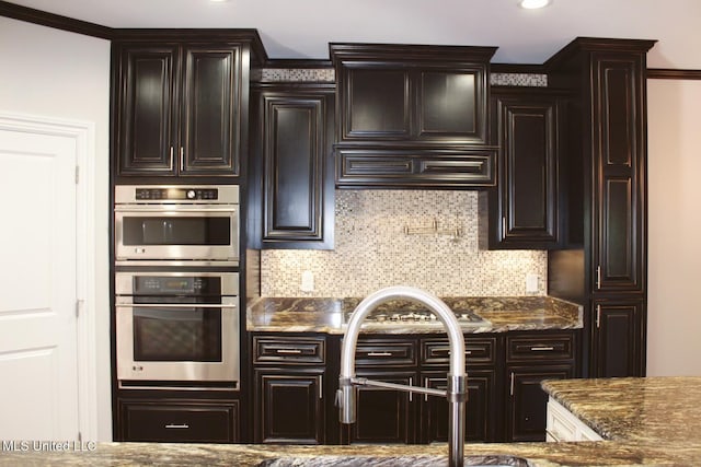 kitchen featuring tasteful backsplash, premium range hood, double oven, and crown molding