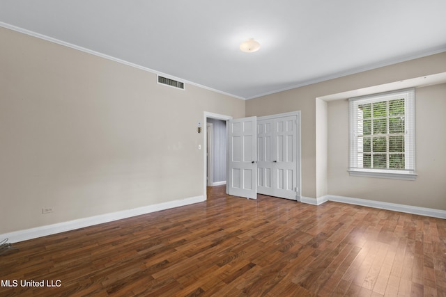 300 S 21st Ave, Hattiesburg, MS 39401 - unfurnished bedroom with ornamental molding, dark wood finished floors, baseboards, and a closet