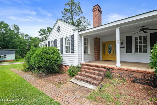 300 S 21st Ave, Hattiesburg, MS 39401 - doorway to property featuring a chimney, covered porch, a ceiling fan, and a lawn